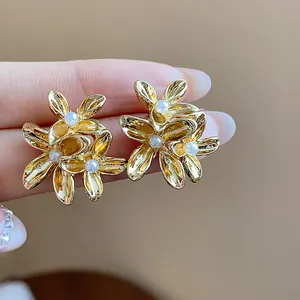 Detail view of vintage flower-shaped stud earrings with gold plating and small pearls