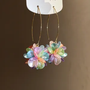 Detail view of colorful iridescent petal flower ball drop earrings with golden wire hooks