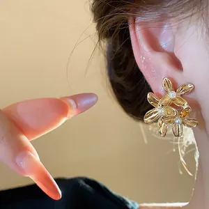Elegant gold flower pearl stud earrings with a French vintage aesthetic detail view.