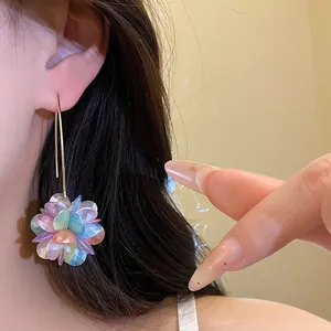 Close-up detail of a colorful petal cluster dangling earring worn by a female model