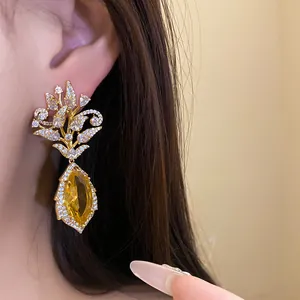 Detailansicht eines exquisiten 18k vergoldeten Blumenohrrings mit gelbem Zirkonstein