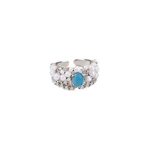Elegant vintage silver open ring featuring an oval turquoise stone, white pearls, and zircons