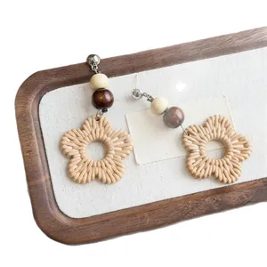 Bohemian handmade woven rattan flower earrings with wooden beads for vacation.