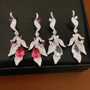 Detailed view of elegant leaf-shaped drop earrings with pink and clear teardrop zircons.