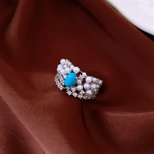 Detailed close-up view of a vintage silver ring featuring oval turquoise, zircon, and pearls.