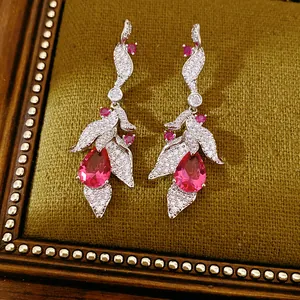 Close-up of pink teardrop and leaf earrings with sparkling cubic zirconia inlay.