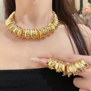 Elegant vintage gold metal textured necklace and matching ring set on fashion model