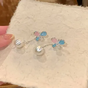 Close-up detail of elegant butterfly tassel earrings with zircon and white pearls