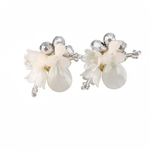 Elegant shell flower stud earrings with pearl water drops and silver beads on white.