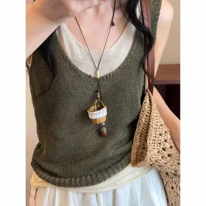 Collier ethnique tissé à la main avec pendentif mini panier et charme en perle de bois.