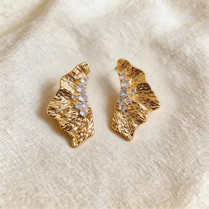 Macro view of 18k gold plated ruffled earrings featuring elegant zircon stone details