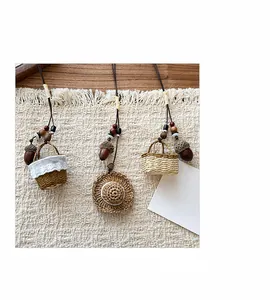 Détail de colliers en panier tressé et chapeau de paille avec glands naturels