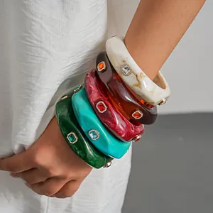 Detailed shot of vintage geometric resin bangles with colorful marble patterns and rhinestones.
