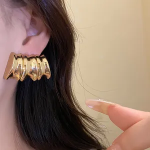 Detailed close-up showing the vintage gold textured chunky stud earrings on model