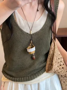 Détail du collier ethnique tissé à la main avec pendentif panier miniature et gland