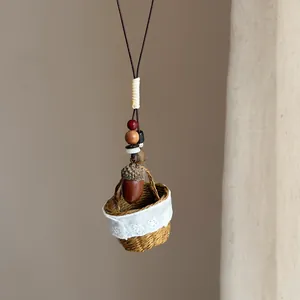 Détail du collier ethnique fait main avec pendentif panier tissé et breloque gland