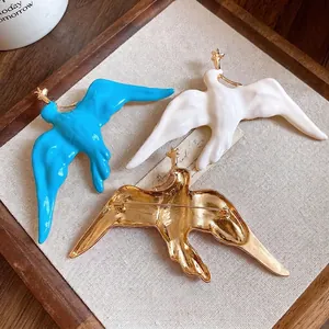 Elegant enamel swallow bird brooch set in vintage gold, blue, and white matte finish