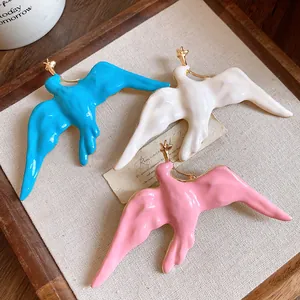 Detail view of colorful enamel swallow brooches in blue, white, and pink vintage style