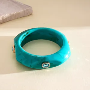 Macro view of turquoise marbled resin bangle featuring sparkling rhinestone inlays