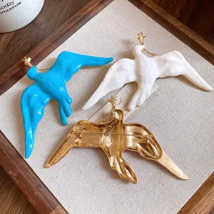 Close-up of vintage metal enamel swallow brooches in blue, white and gold plating detail
