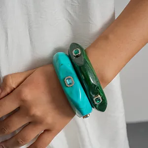 Macro detail view of vintage marbled resin bangles with emerald and turquoise crystal inlays