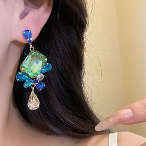Vintage gold-tone drop earrings with faceted square green crystal and blue stones.