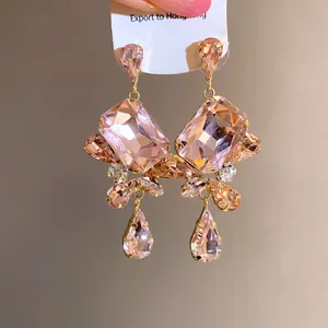 Macro detail of vintage pink rhinestone square drop earrings with gold-tone finish