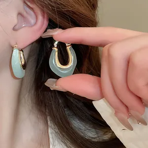 Close-up of K-style U-shaped mint green resin earrings with gold-toned metal clasp