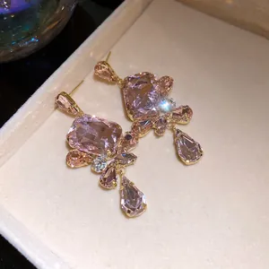 Detailed macro view of vintage pink square crystal drop earrings in a velvet box