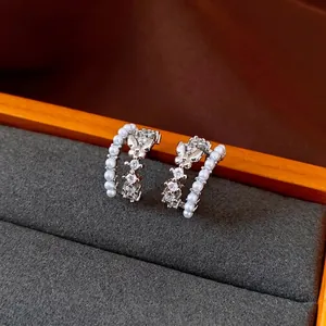 Elegant C-shaped butterfly stud earrings with pearls and shimmering zirconia accents