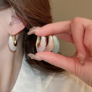 Close-up of minimalist U-shaped jelly resin hoop earrings in various colors for women.
