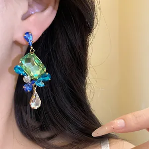 Detailed view of vintage square pendant earrings with colorful rhinestones on ear.