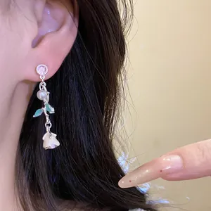 Close-up showing the elegant floral drop earrings with zircon, pearl, and enamel design