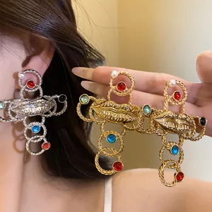 Close-up detail of retro lip cross jewelry with colorful resin stones and pearls