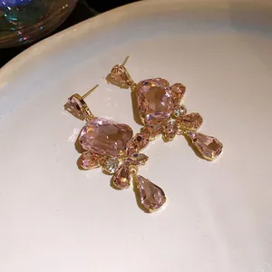 Close-up of vintage-style pink square crystal dangle earrings with faceted gems
