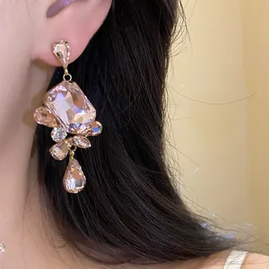 Detailed close-up showing vintage-style square crystal drop earrings with pink stones