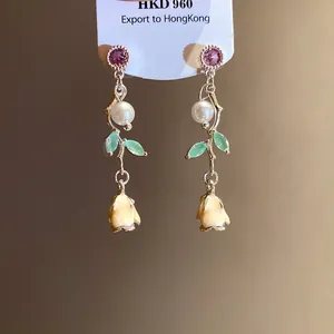 Detail view of sweet style drop earrings with zircon pearl and enamel flower pendants