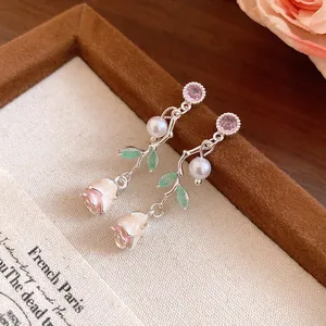 Detailed close-up view of elegant silver rose earrings with pearls and pink zircons