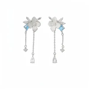 Eleganti orecchini a fiore con zircone blu e catenine d'argento su sfondo bianco