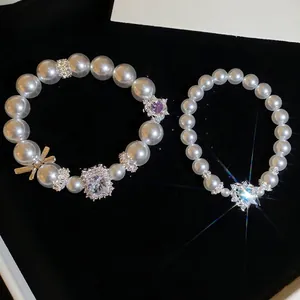Französisches Perlenarmband-Set mit Herz- und Schleifenanhängern, Vintage-Stil.