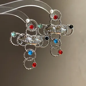 Vintage silver-toned cross earrings featuring resin pearls and unique lip design details.
