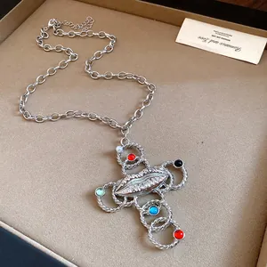 Vintage silver-tone cross necklace featuring a metallic lip motif and colorful resin beads