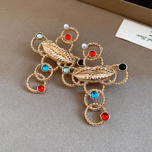Detail view of a vintage gold cross pendant featuring a lip motif and colorful resin beads
