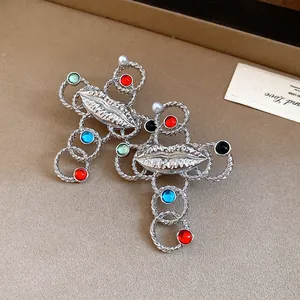 Detailed view of silver-tone cross necklaces with lips design and colorful beads