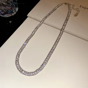 Detailed view of elegant double-row square-cut rhinestone tennis necklace on cream surface