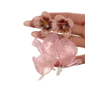 Handcrafted pink beaded floral earrings with layered fabric petals and elegant tassels