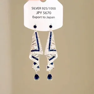 Eleganti orecchini pendenti in argento con pietre blu zaffiro e accenti di cristallo.