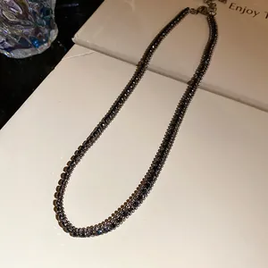 Close-up of an elegant black rhinestone choker with sparkling square-cut crystals.