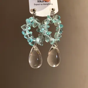Dettaglio di orecchini vintage con pietre blu e pendenti a goccia trasparenti