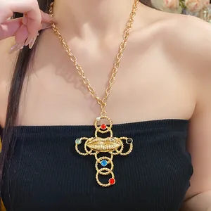 Vintage gold cross necklace with lip motif and colorful resin beads worn by a model.